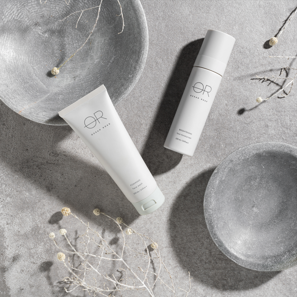 Brightening Face Moisturiser on a grey surface with decorative elements.