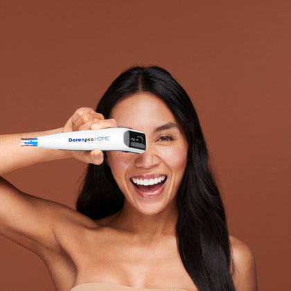 Woman holding a Dermaroller against a brown background