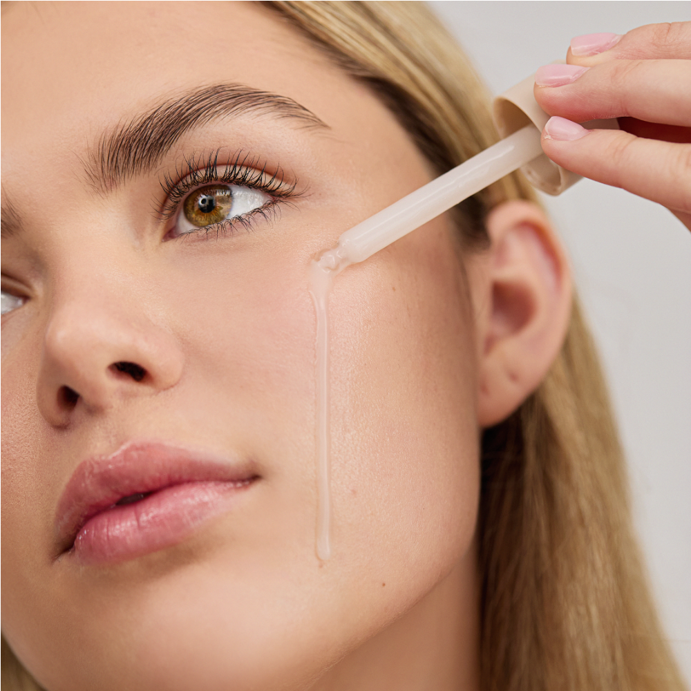 Woman applying Liquid Hydrator o their face using a small applicator.