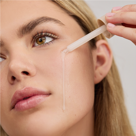 Woman applying Liquid Hydrator o their face using a small applicator.
