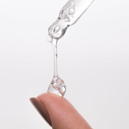 Tremella & B3 Serum being dripped from a dropper onto a finger against a white background
