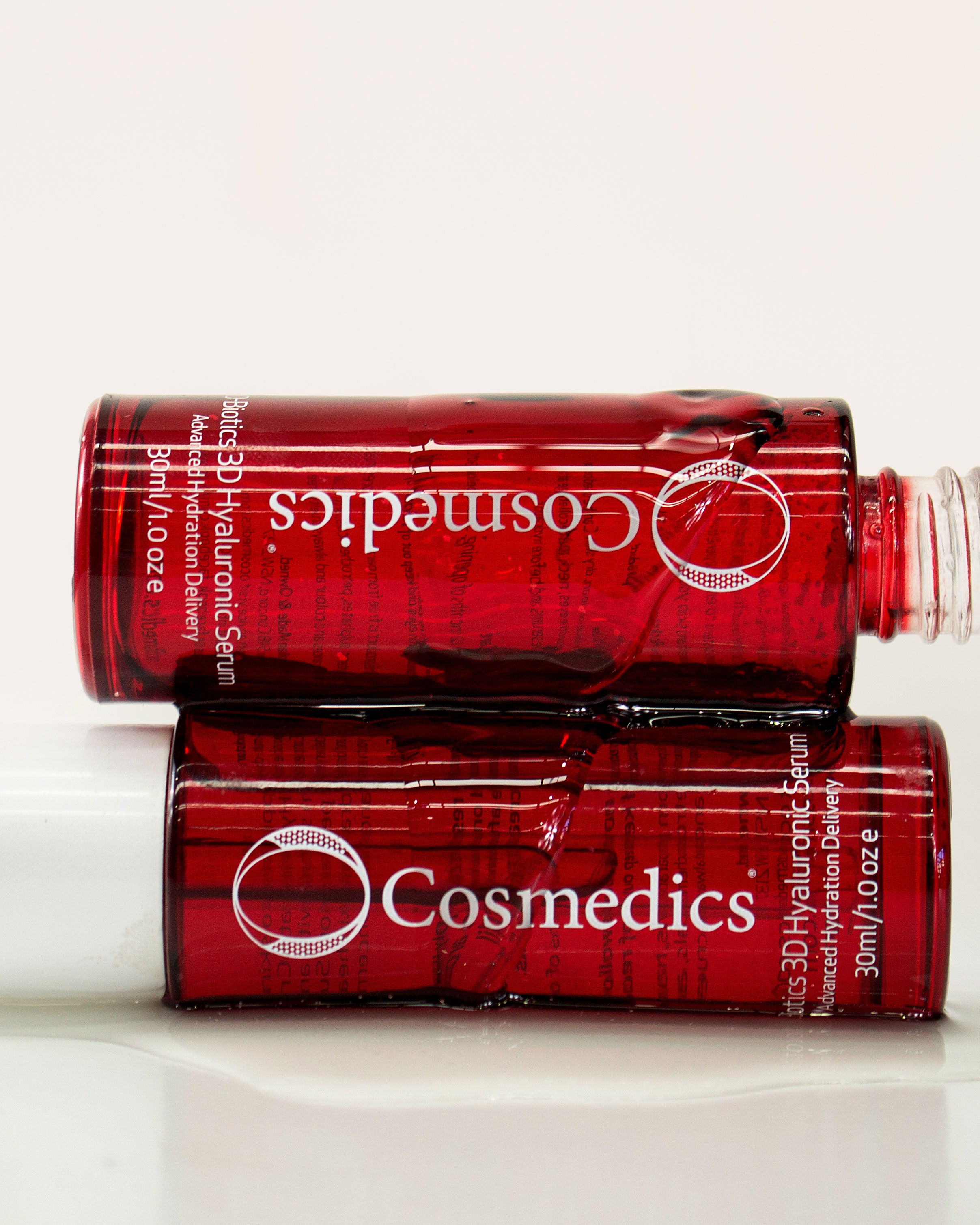 Two red bottles of  'O' 3D Hyaluronic Serum on a white background