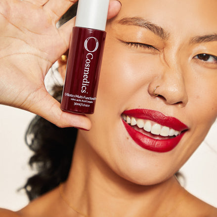 Woman with red lipstick holding 'O' Multi-Functional Peel close to her face.