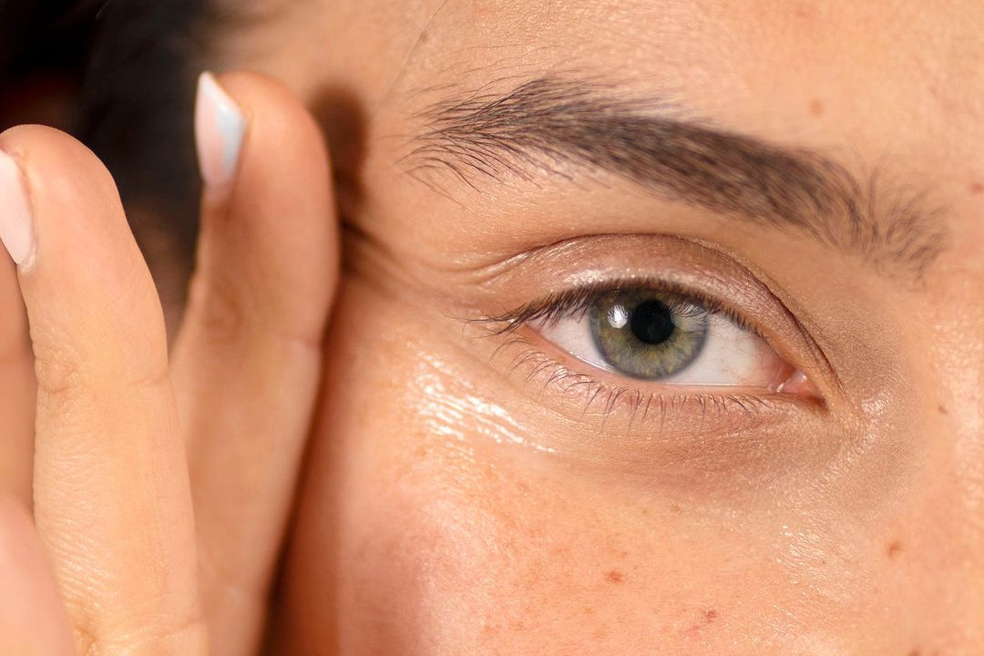 Close-up of a person applying cream to their face with aCosmedix logo.