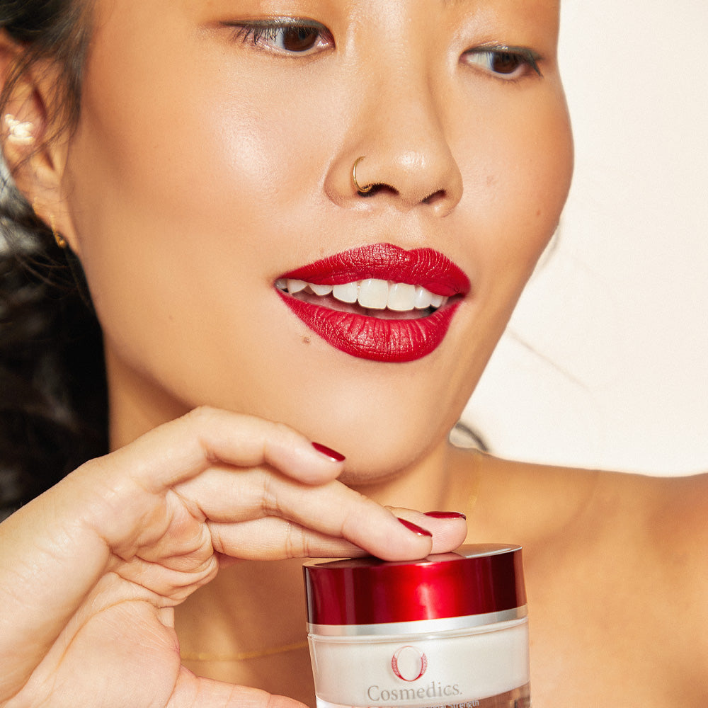Woman with red lipstick holding 'O' Pure C + BHA with a neutral background
