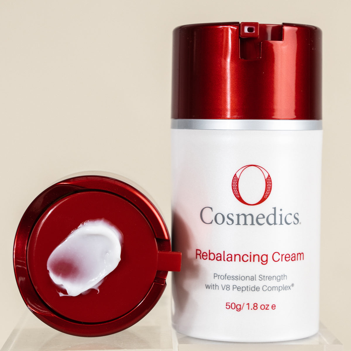 'O' Rebalancing Cream with red cap and white body on beige background