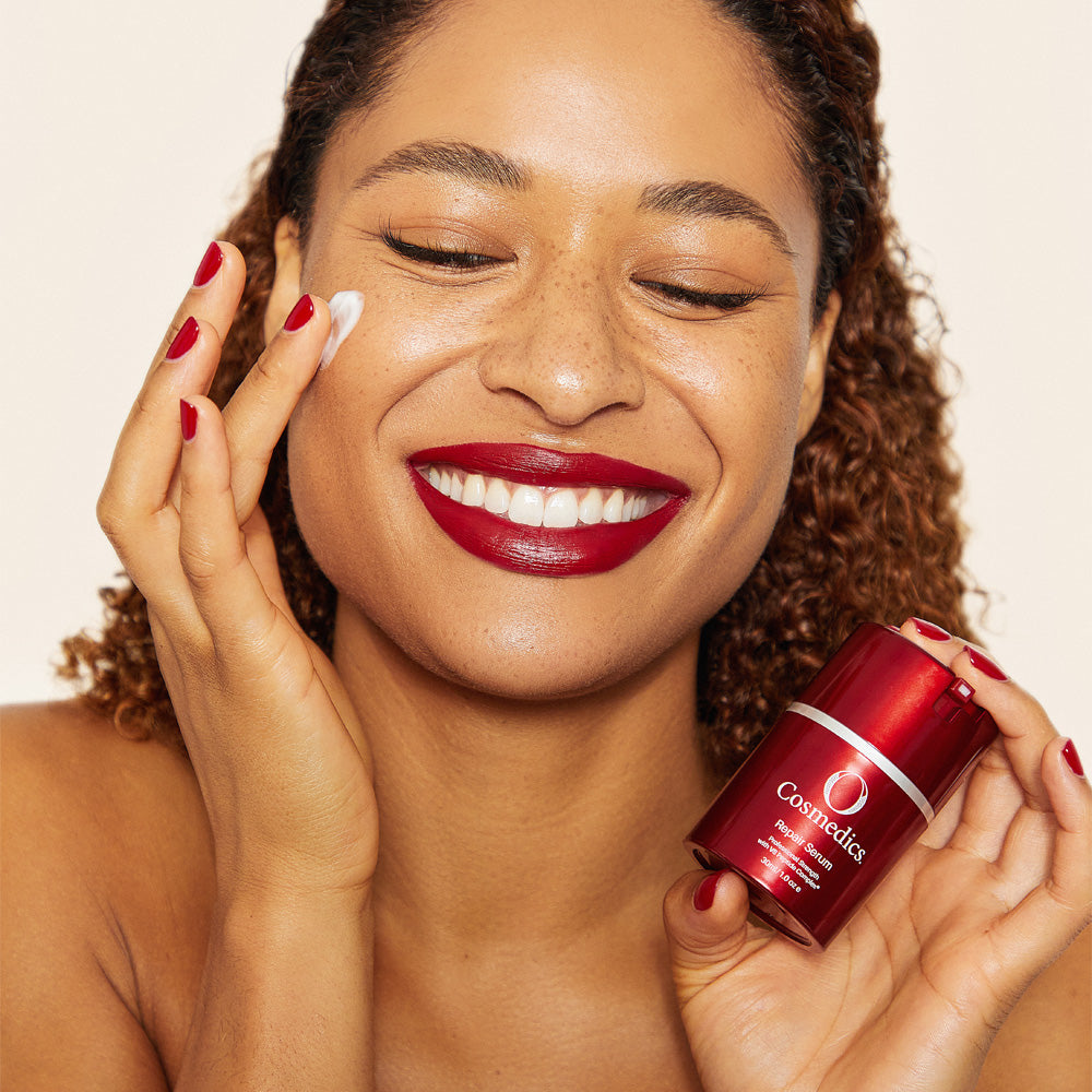 Woman 'O' Repair Serum to her face with OCosmedics product in the foreground