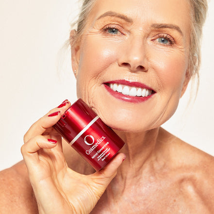 Woman holding 'O' Retinol Concentrate 1% on a beige background