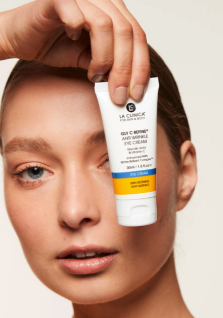 Person holding a tube of Resurfacing Anti Wrinkle Eye Cream above their eye.